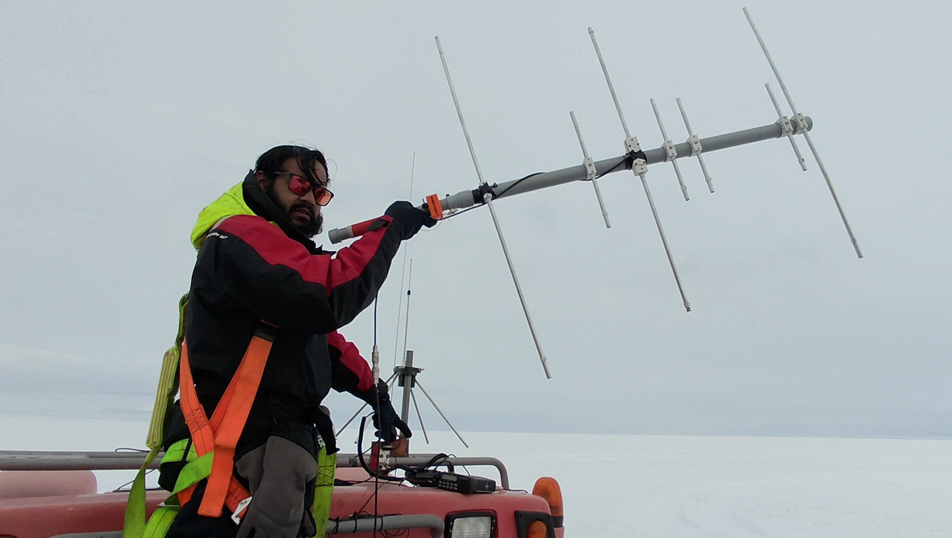 Holding the Yagi antenna for VHF/UHF satellite communications — Antarctica field operations.